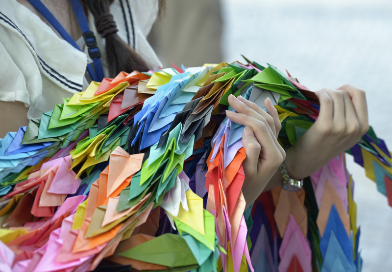 A Japanese girl carries folded paper cranes she has brought to Hiroshima in commemoration of the 70th anniversary of the U.S. dropping an atomic bomb on the Japanese city of Hiroshima. The cranes are a sign of hope and peace.