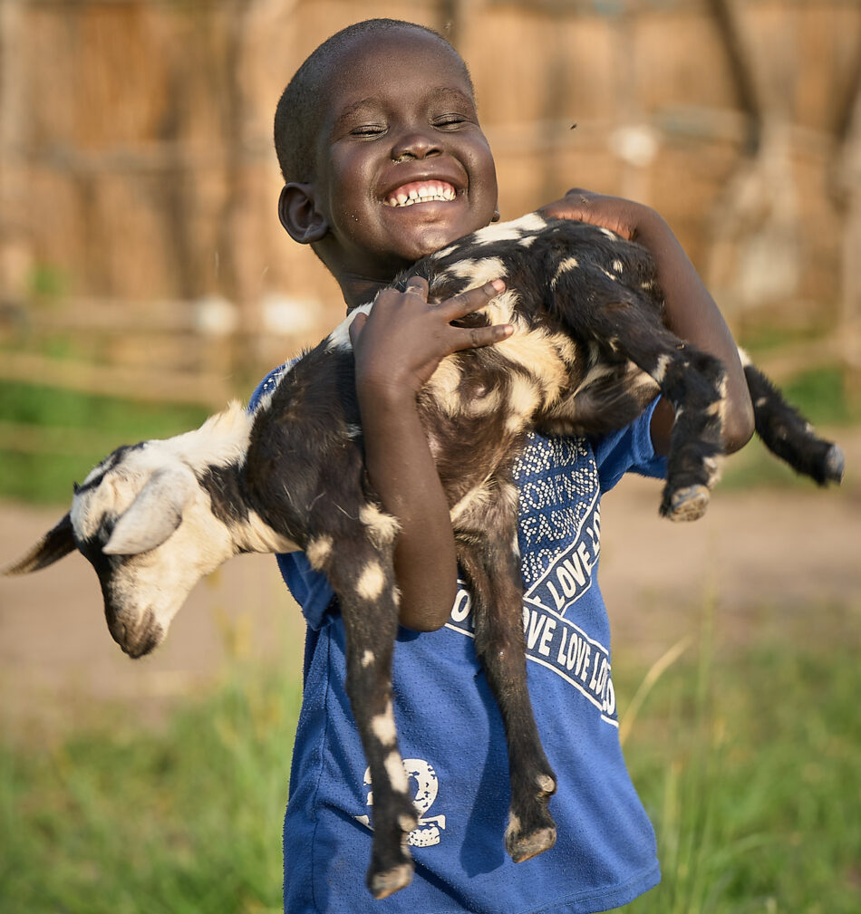 A boy holds one of his family's goats in Mogok, South Sudan.
