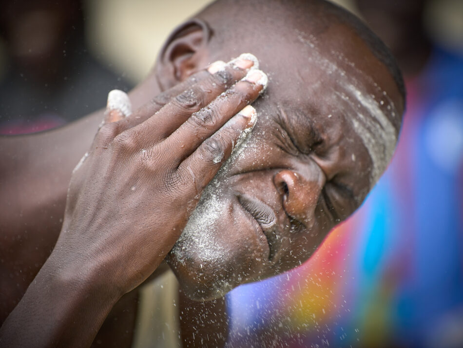 A student at the Solidarity Teacher Training Institute in Yambio, South Sudan, wipes ash on his face in preparation for tribal dancing with other students. To bridge cultural gaps that often lead people in the war-torn country to violence, students intentionally learn the songs and dances of the tribes of other students in the school.  The school is sponsored by Solidarity with South Sudan
